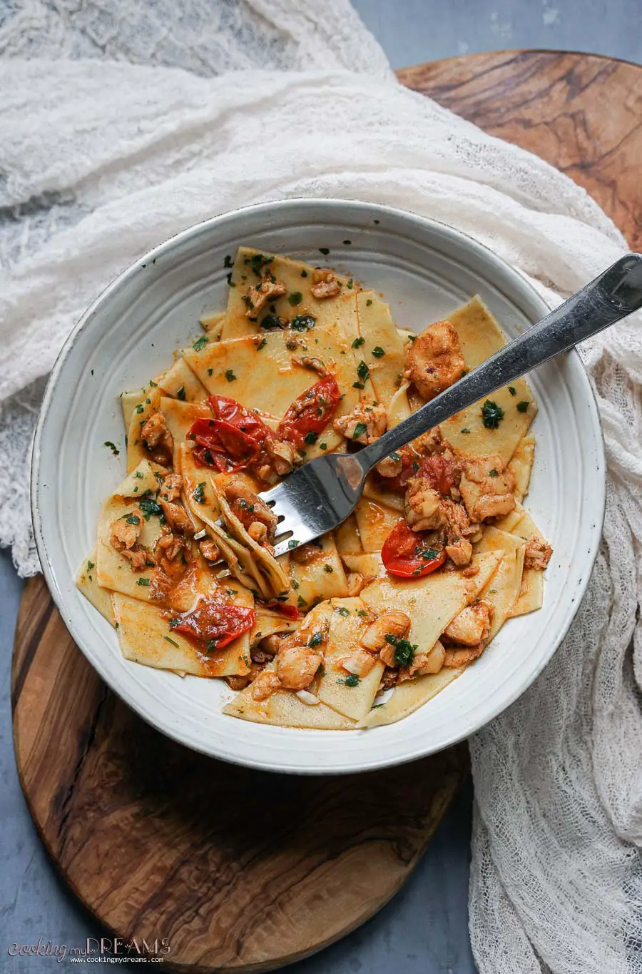 Bowl of fish and tomato pasta with fork 
