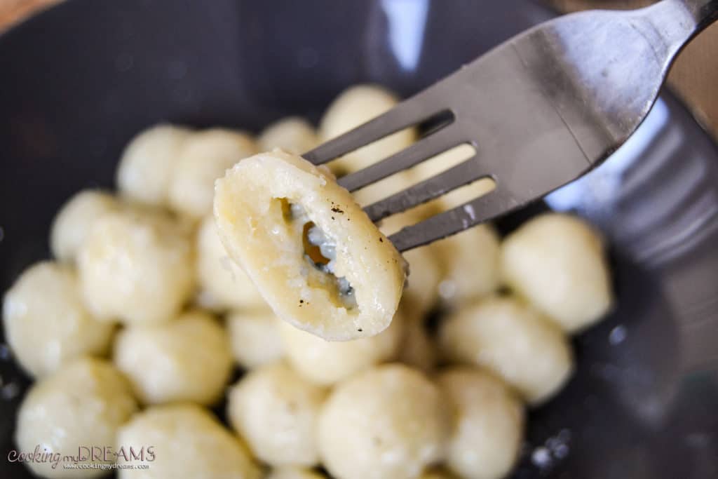 potato gnocchi on a fork, stuffed with gorgonzola
