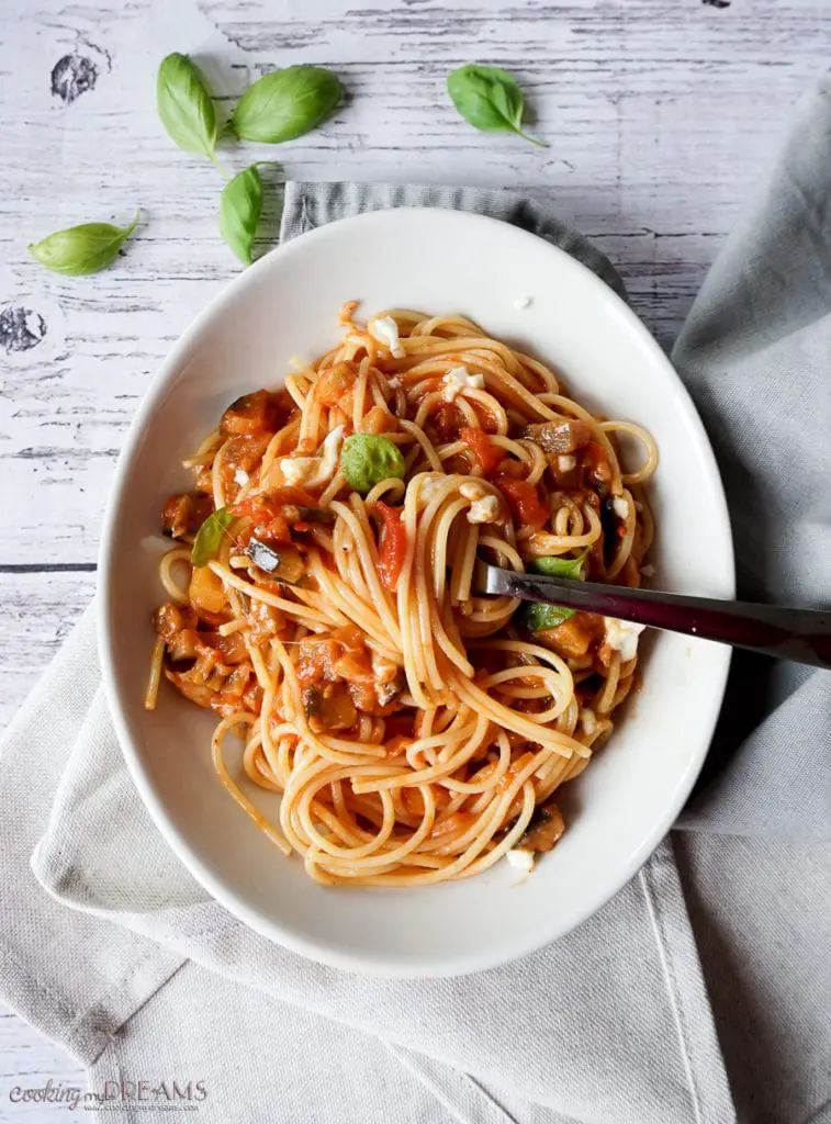 plate of spaghetti with tomato eggplant mozzarella sauce