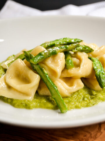 cheese cappelletti with asparagus on a plate