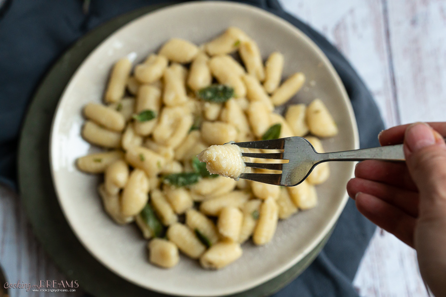 fork holding a gnocchi over the plate