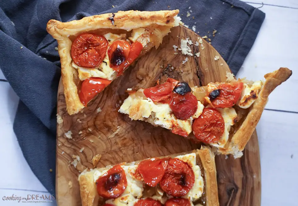 tomato tart cut into slices on a cutting board