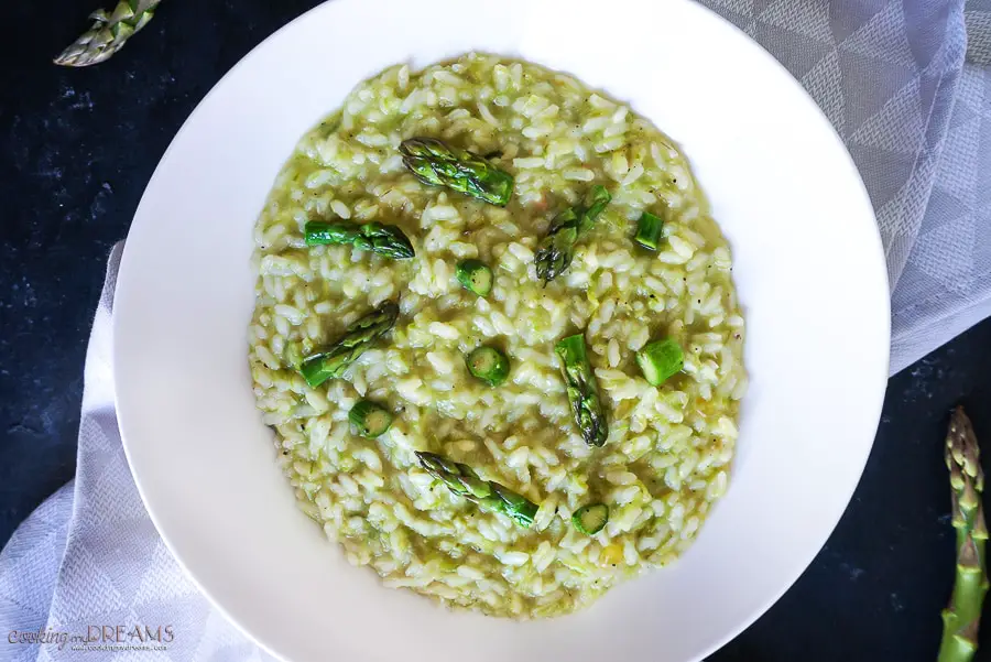 overhead photo of asparagus risotto in white dish