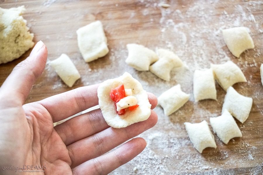 hand stuffing a gnocchi with tomato and mozzarella