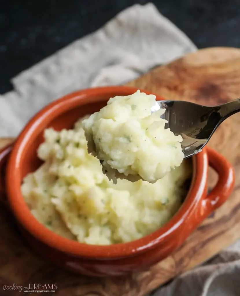 garlic mashed potatoes in terracotta bowl and on a spoon