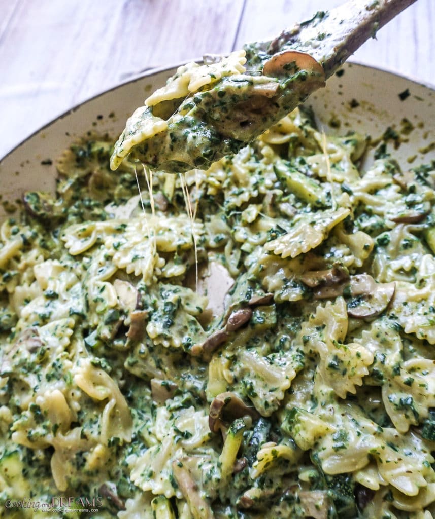 cheesy pasta with spinach mushroom zucchini in a pan
