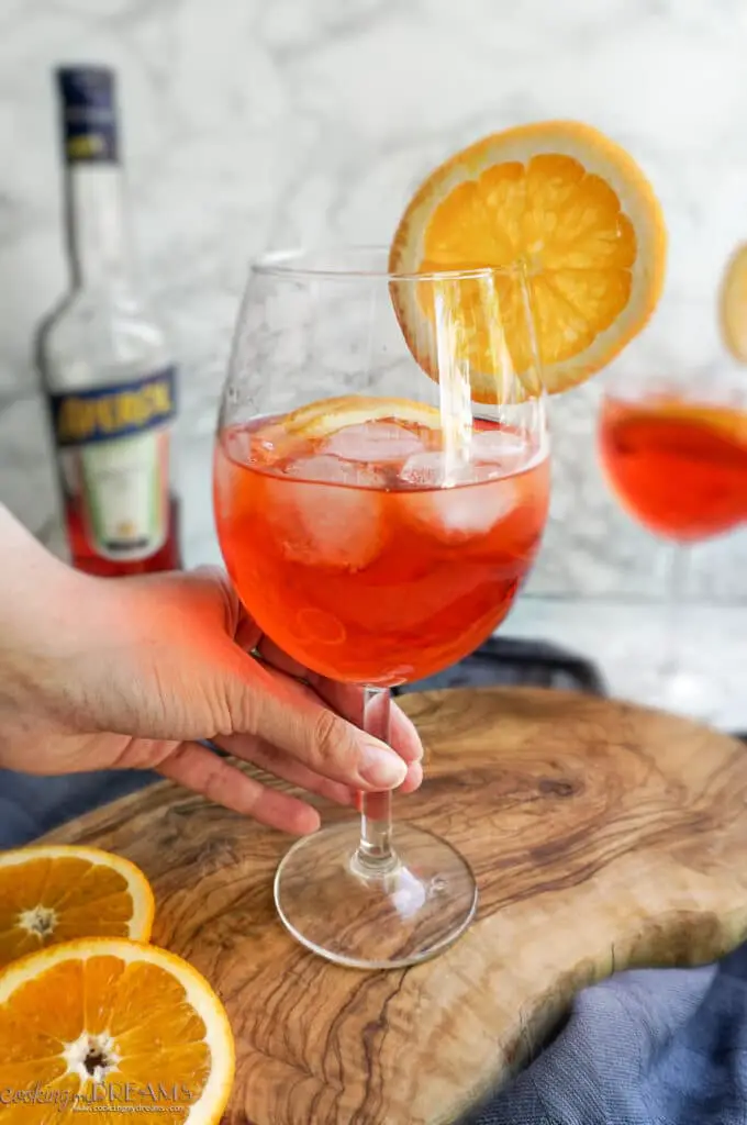 hand holding a glass of aperol spritz