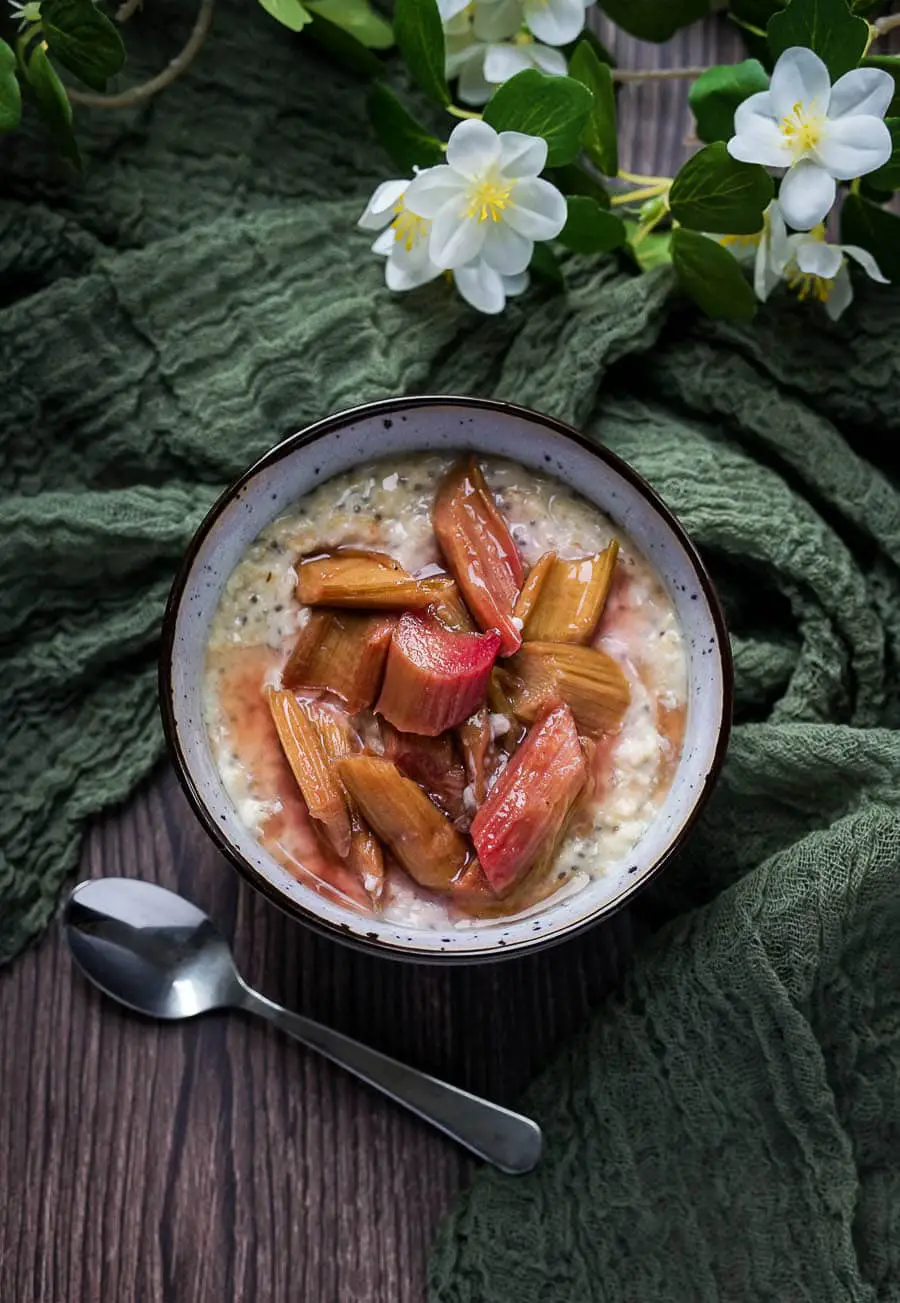 vanilla oatmeal in a bowl topped with roasted rhubarb