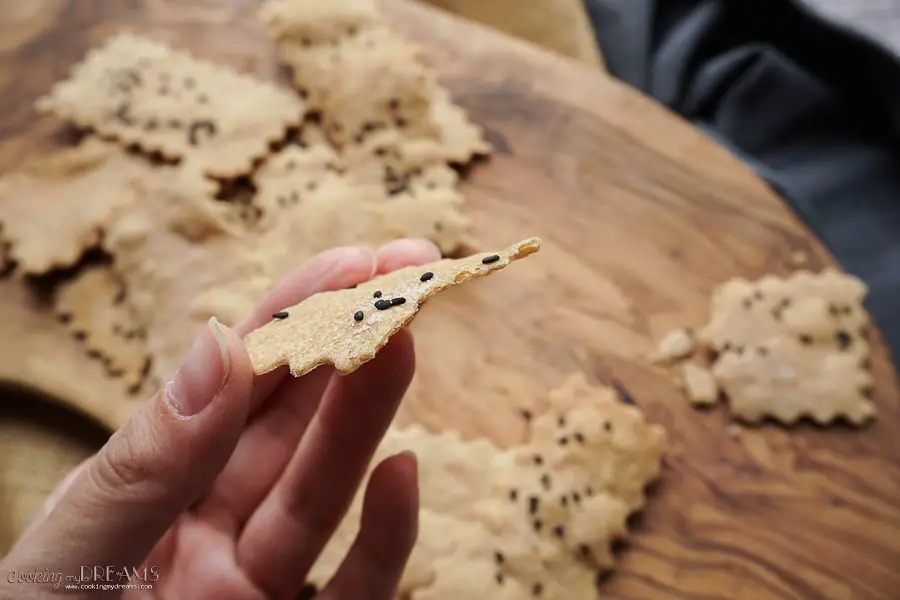 hand holding up half thin cracker