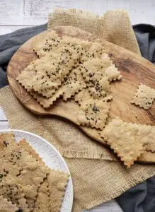 cumin spelt crackers on a plate and on a wooden board