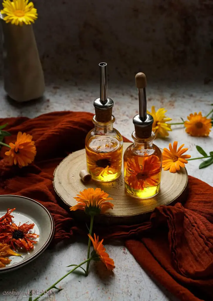 bottles of calendula oil surrounded by marigold flowers