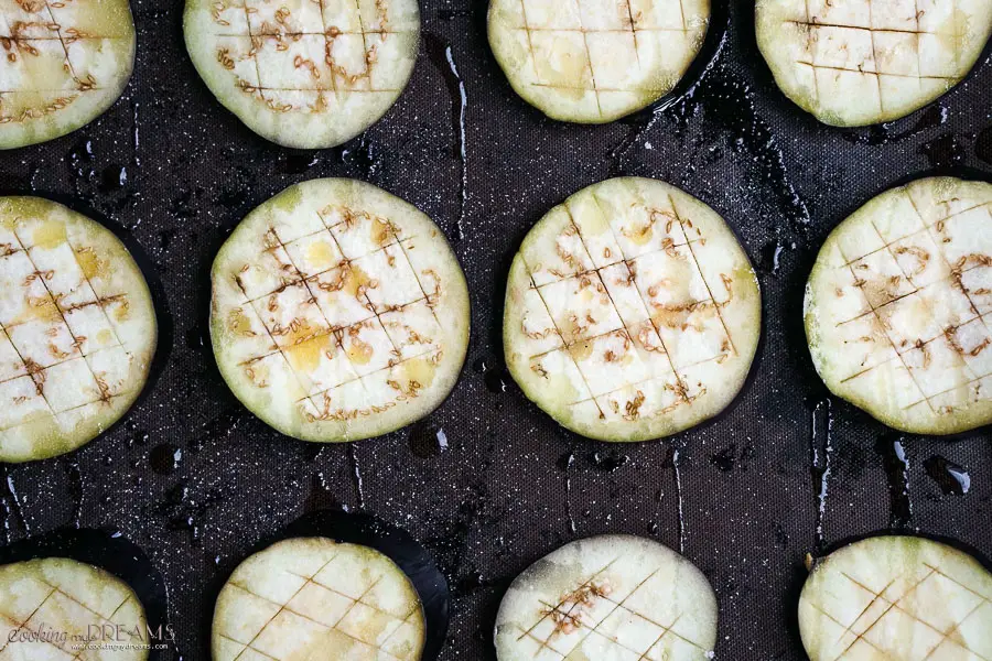 raw aubergine slices on a baking tray