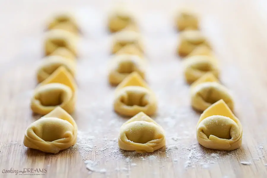 tortelli lined up on a wooden board