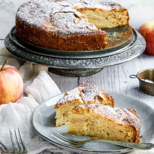 two slices of italian apple cake on a plate in front of the cake