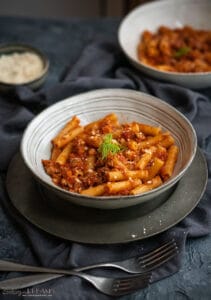 white dish with pasta with sausage tomato sauce