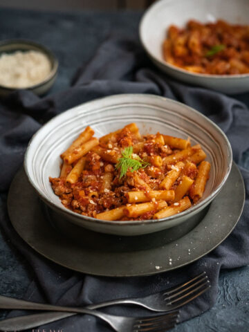 white dish with pasta with sausage tomato sauce
