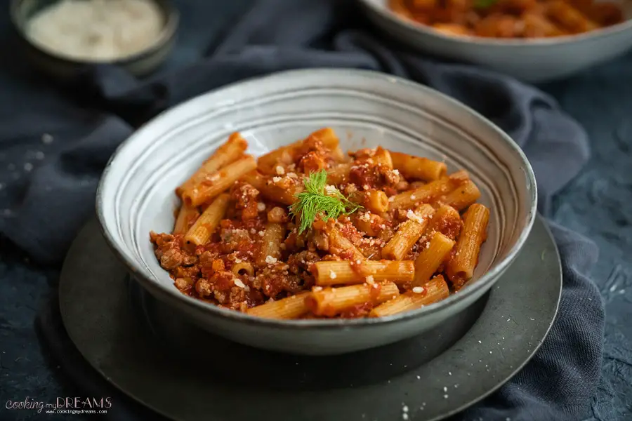 white dish with pasta with sausage tomato sauce
