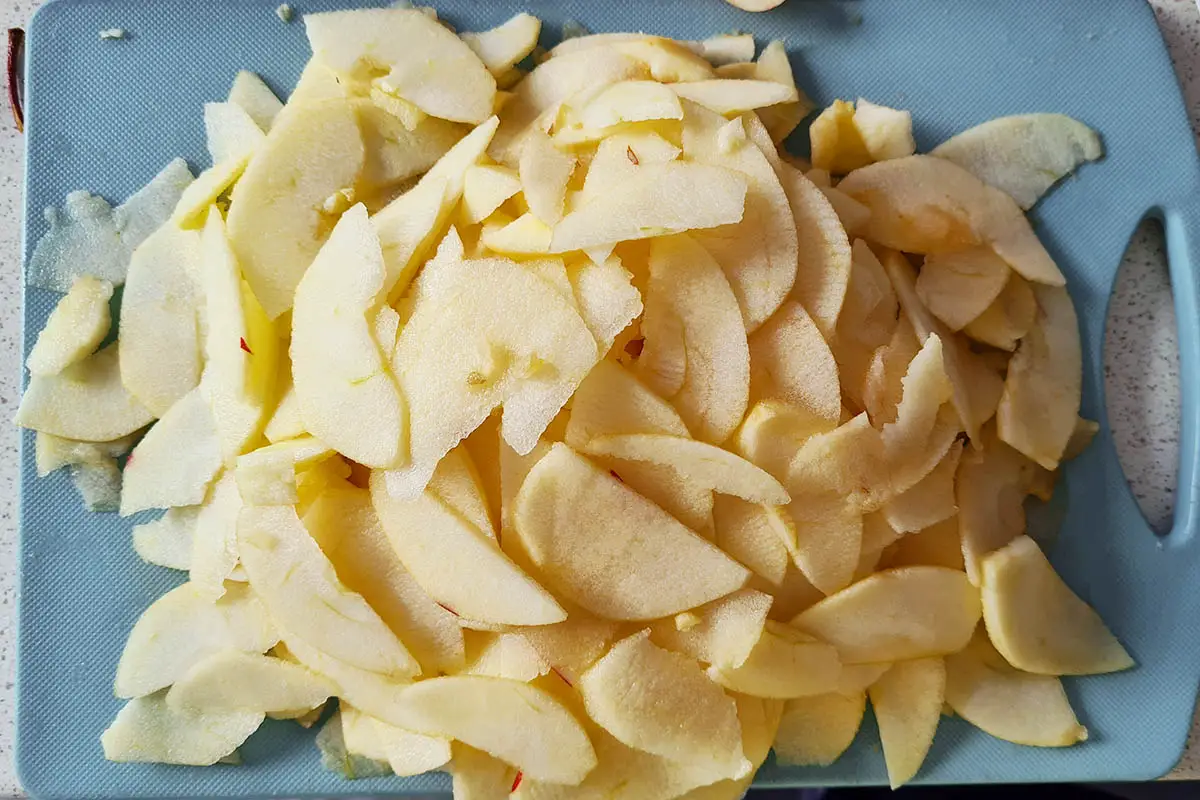 thinly sliced apples on a cutting board.