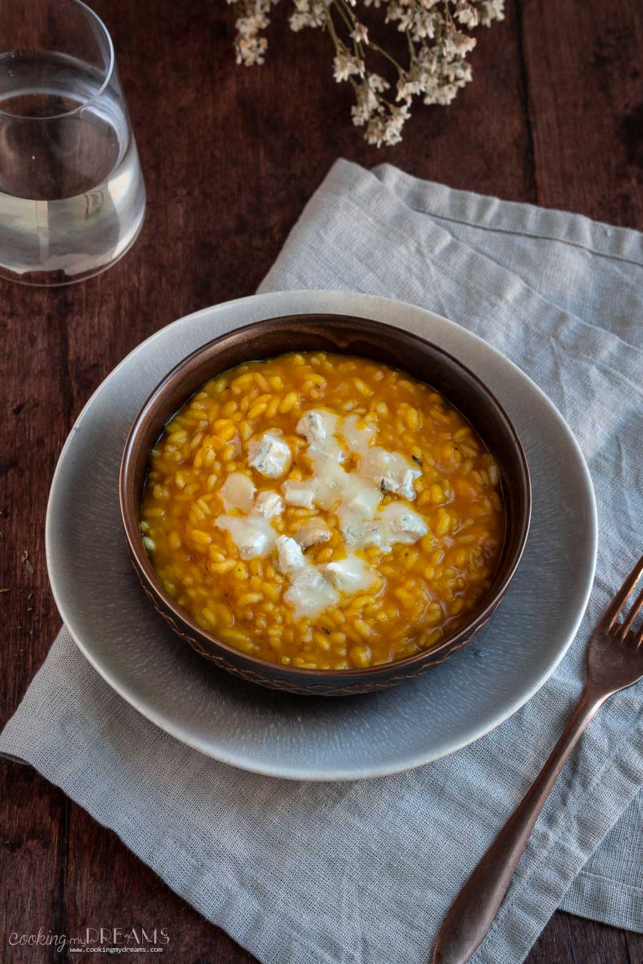 brown bowl with pumpkin risotto and gorgonzola cheese