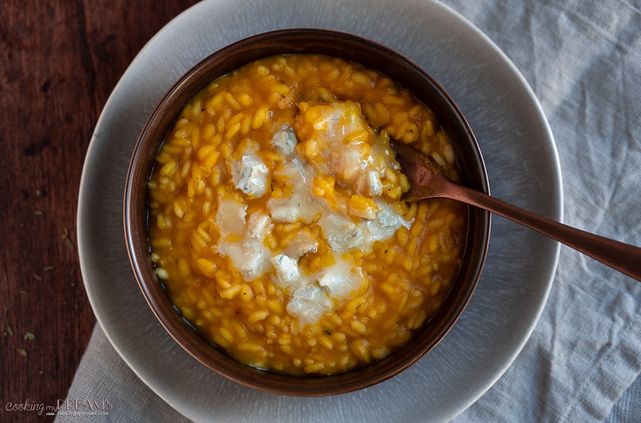 brown bowl with pumpkin risotto with a fork