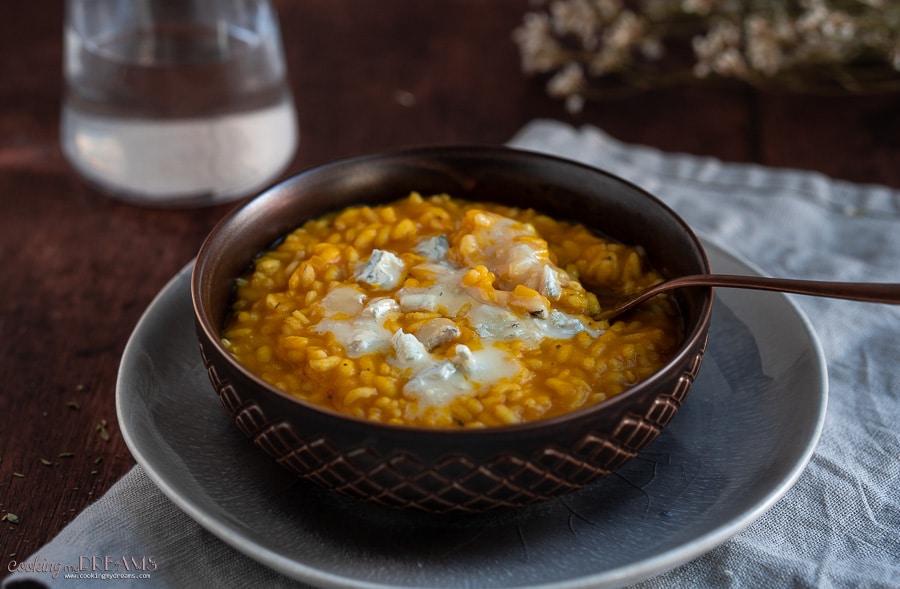 brown bowl with pumpkin risotto with a fork