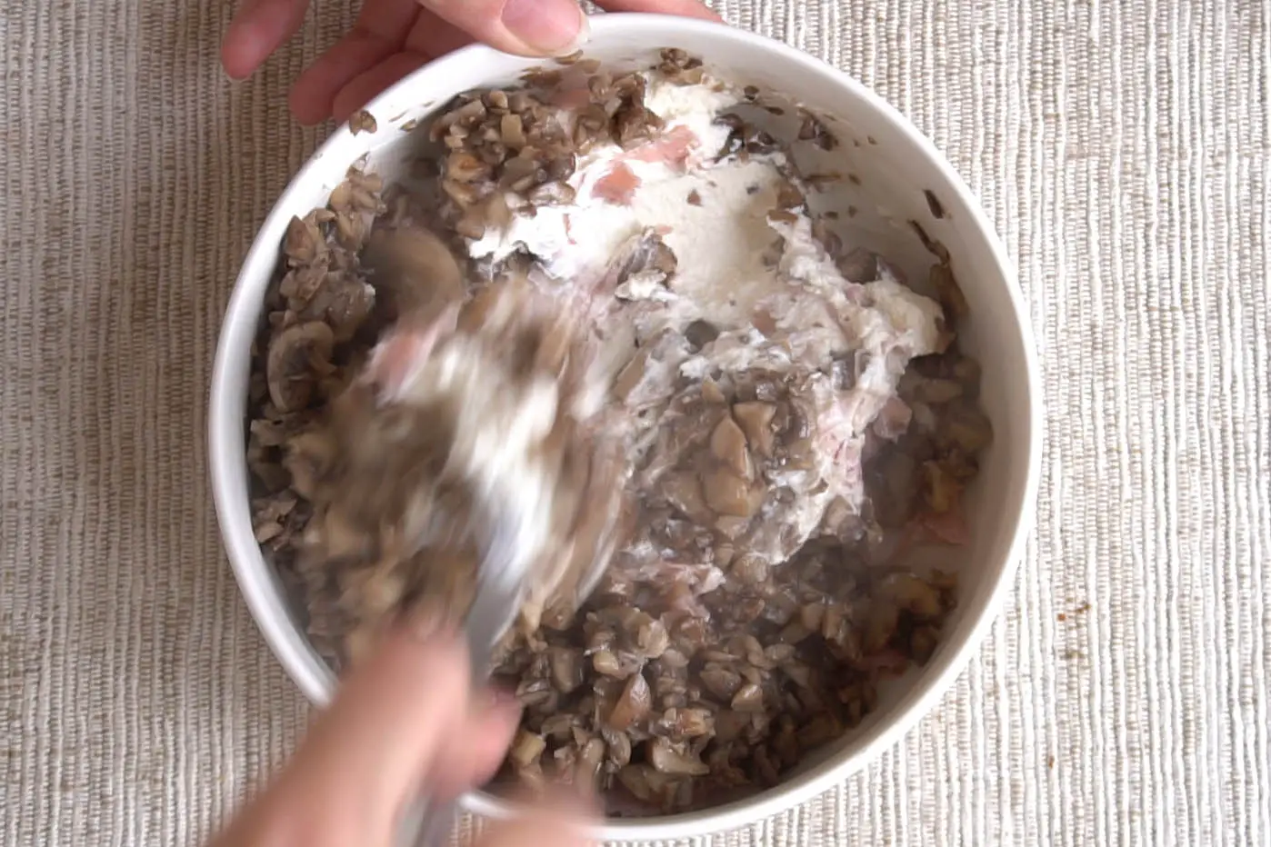 mixing mushrooms and ricotta in a bowl