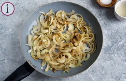 sliced onions cooking in a pan