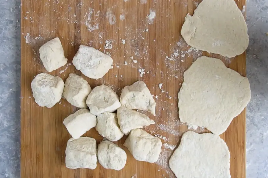 dough is divided in pieces and flattened on a board