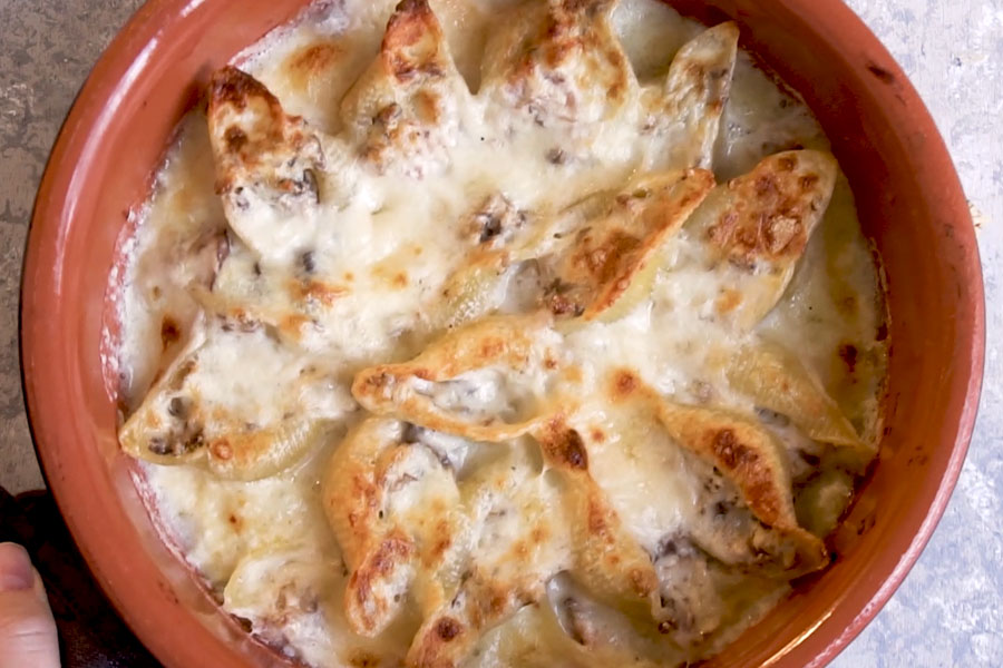 baked stuffed shells in a terracotta pot out of the oven