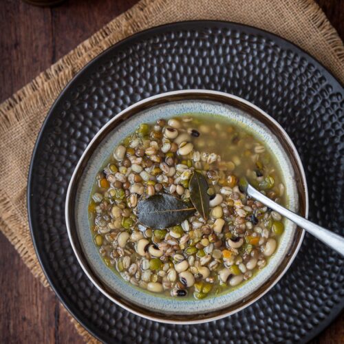bowl with legumes and cereal soup and a spoon