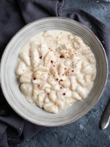 overhead grey bowl with potato gnocchi with four cheese sauce