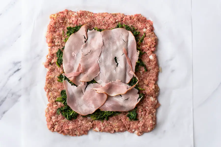 slices of ham are added on top of the meat and spinach