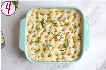 raw focaccia topped with rosemary ready to be baked
