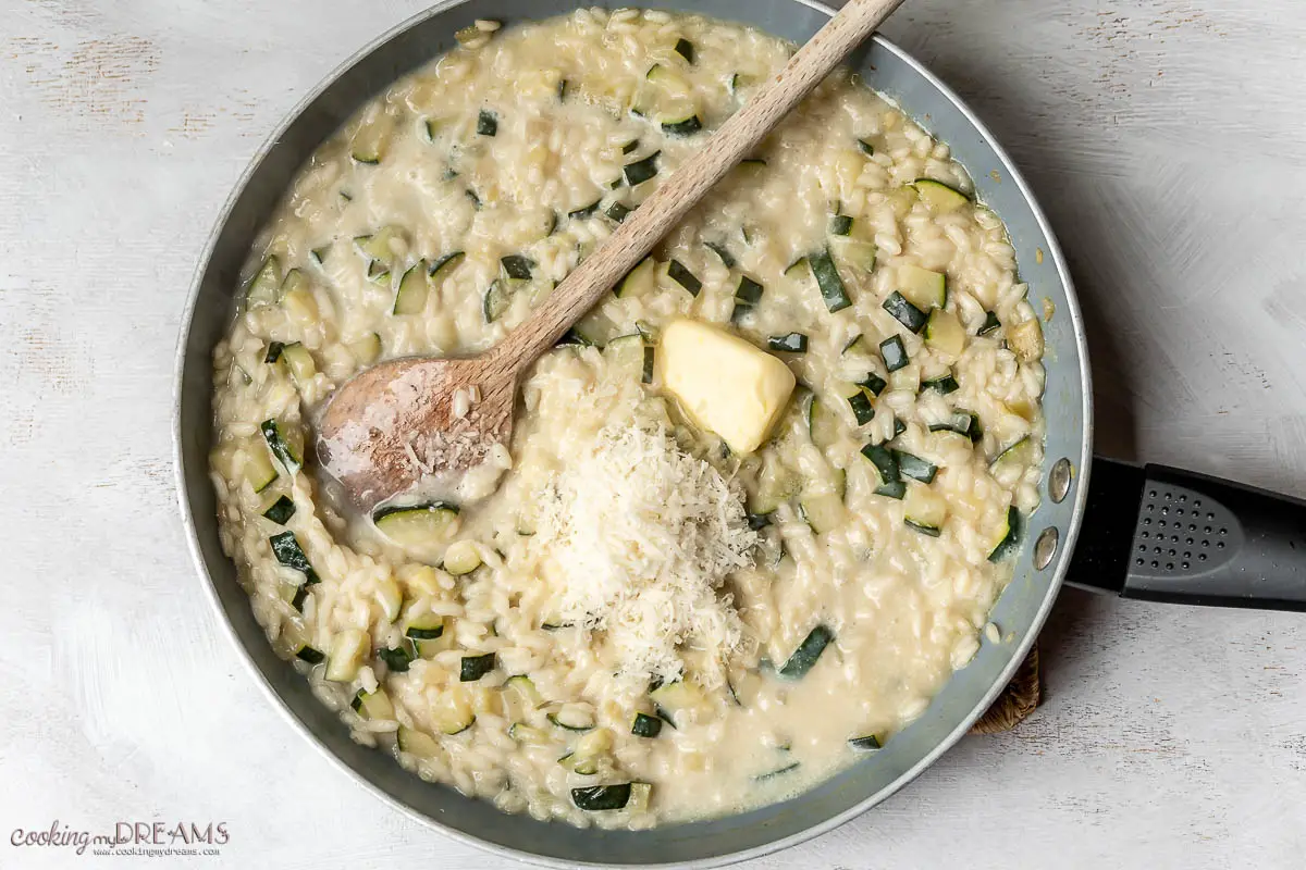the risotto is finished with parmigiano and butter in the pan