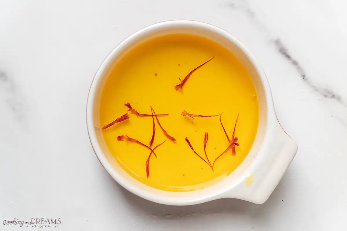 saffron threads steeping in a cup of warm water