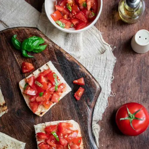 bread and tomatoes on a wooden cutting board