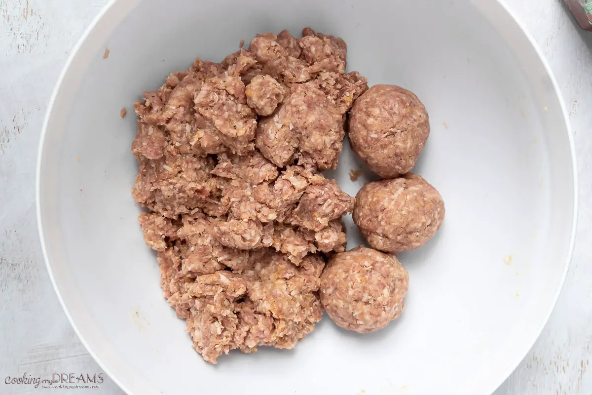 half of the meat mixture is formed into meatballs in the bowl