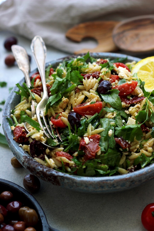 bowl of greek orzo salad with a spoon
