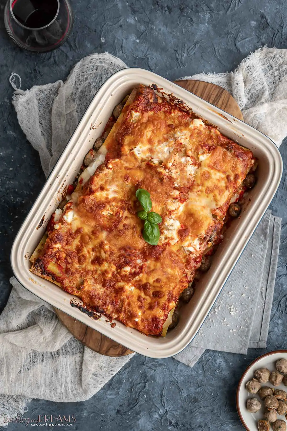 overhead of a meatball cheese lasagna in a baking pan