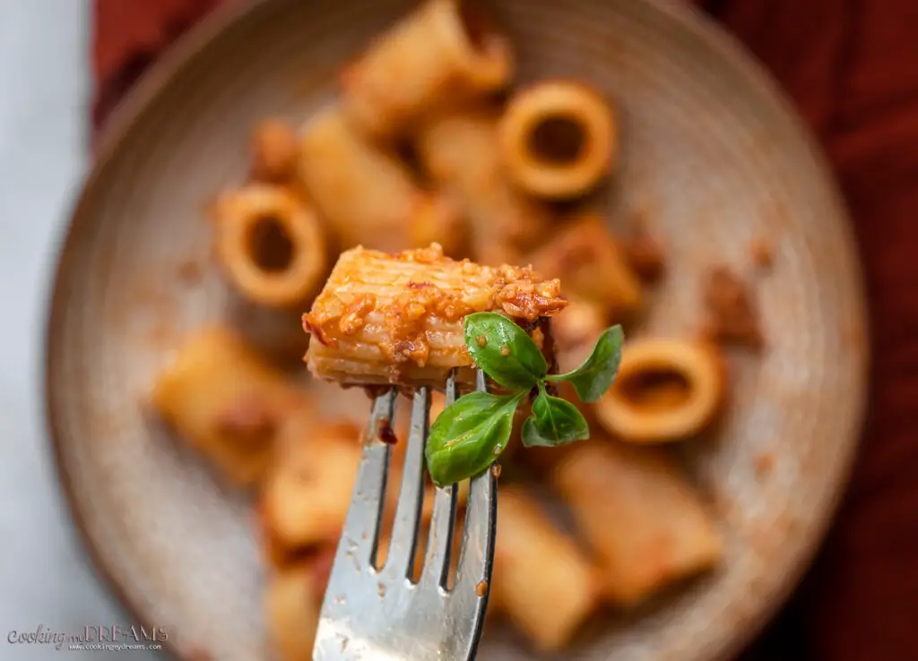 fork holding pasta with basil leaves