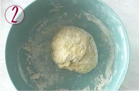 pasta dough kneaded inside a blue bowl