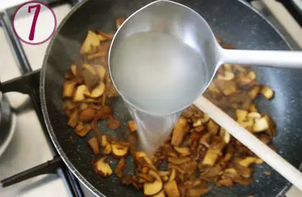 ladle pouring pasta water in the pan with the mushrooms