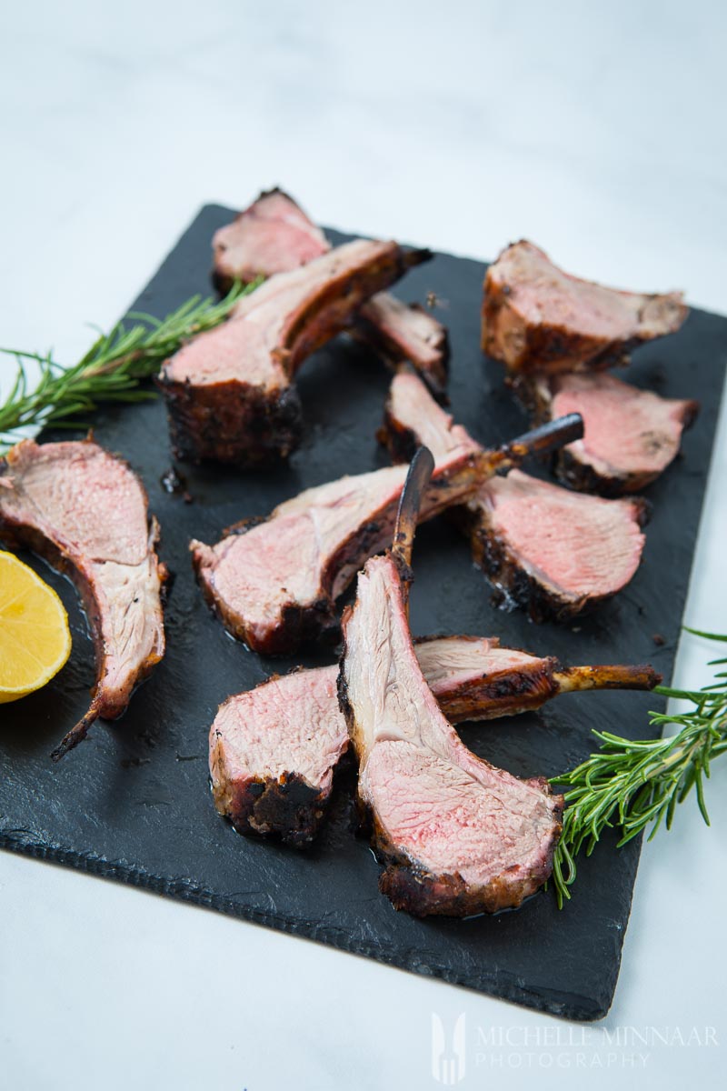 bbq lamb chops on a board with rosemary