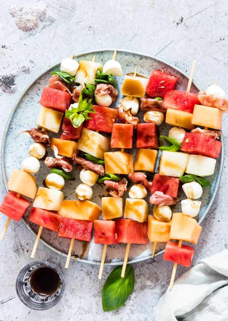 plate with watermelon and mozzarella skewers