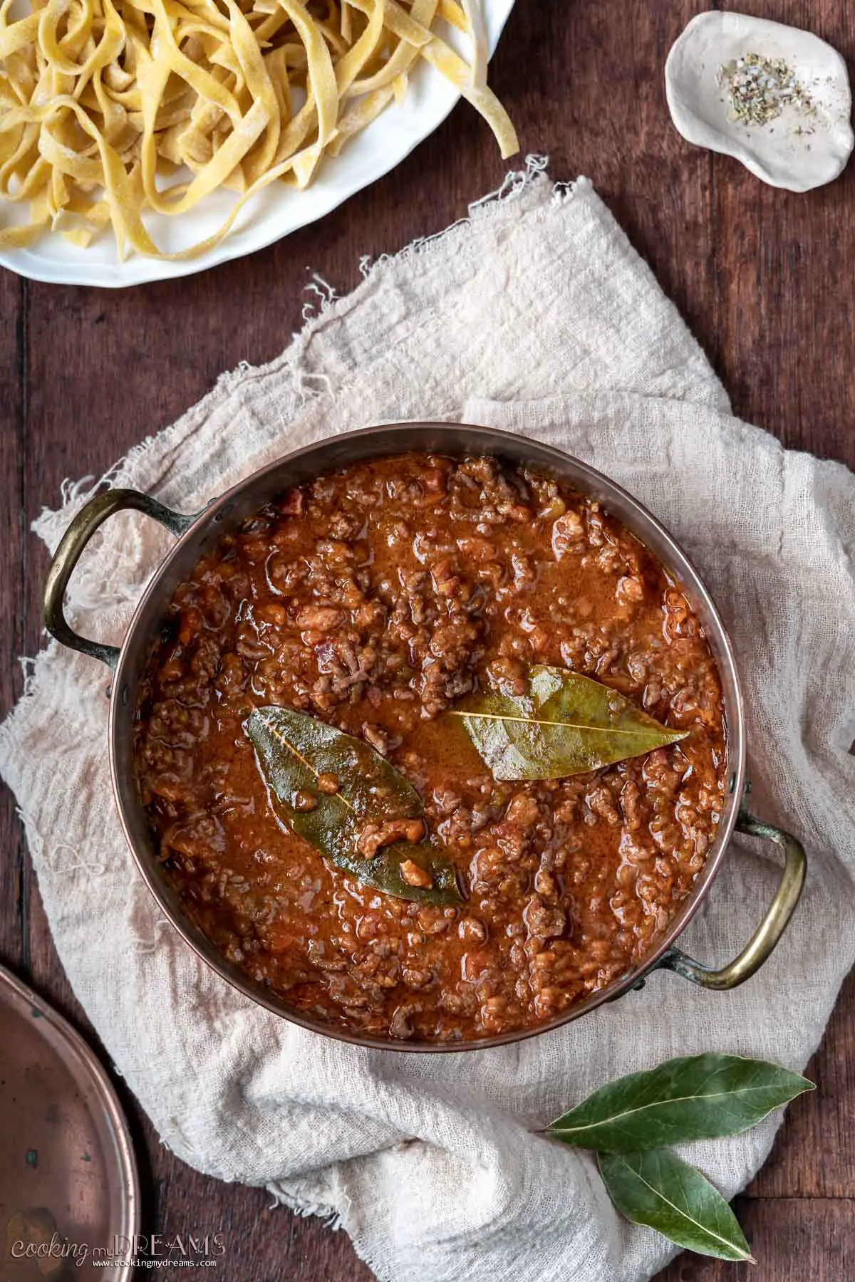 pot of beef ragù with bay leaves on top