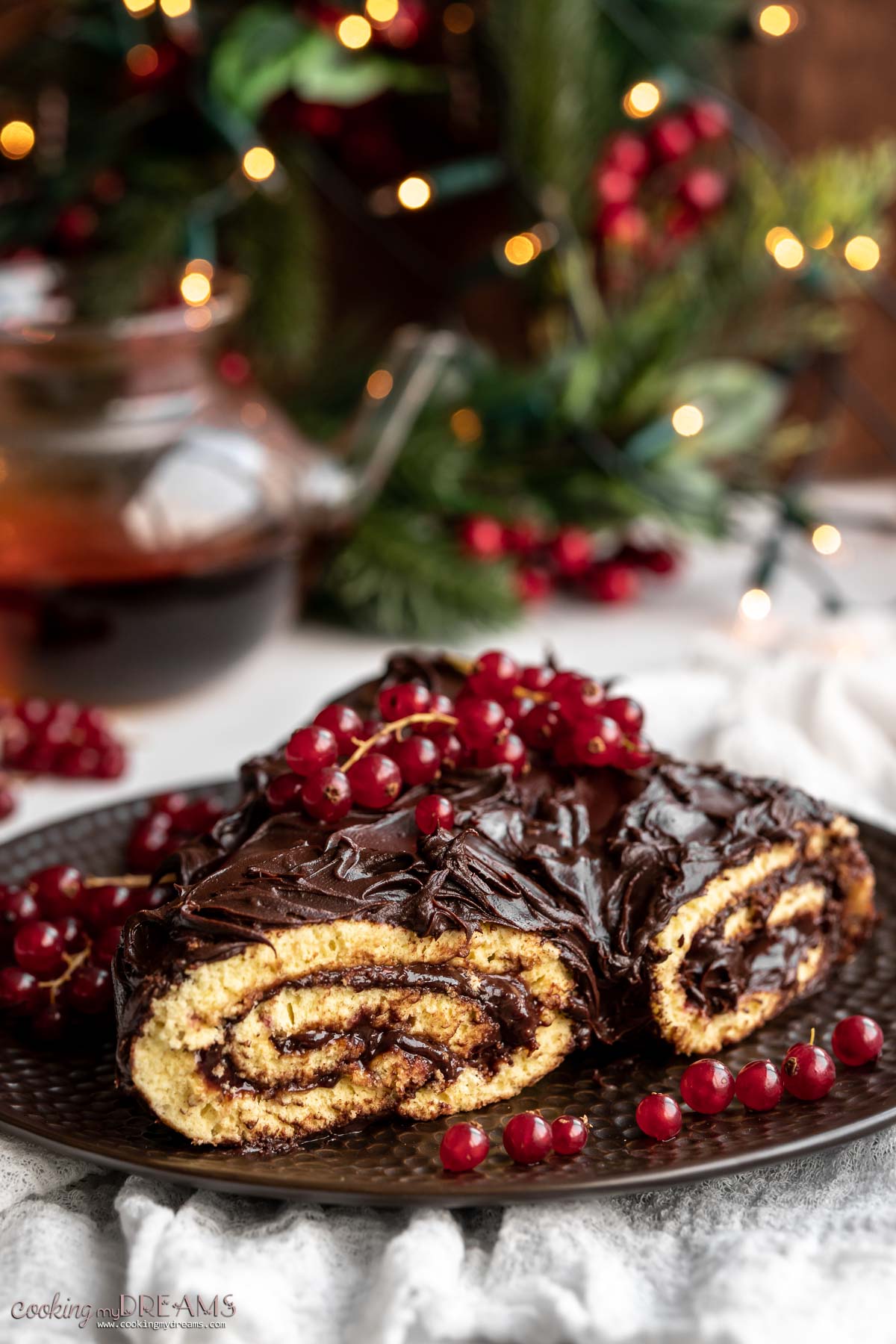 buche de noel cake on a serving plate with red currants