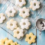 flower shaped cookies italian canestrelli on a blue table dusted with powder sugar