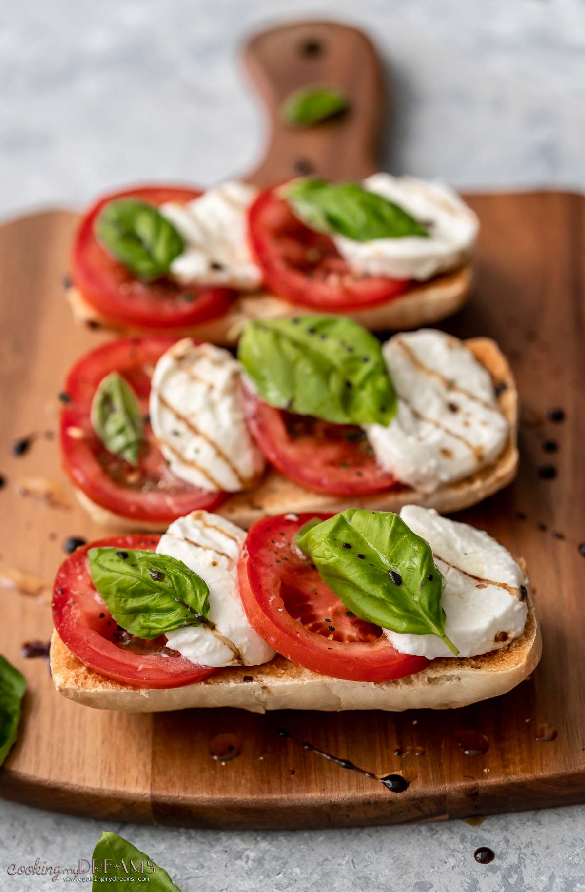 close up of bread slices topped with mozzarella, tomato and basil