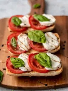 close up of bread slices topped with mozzarella, tomato and basil