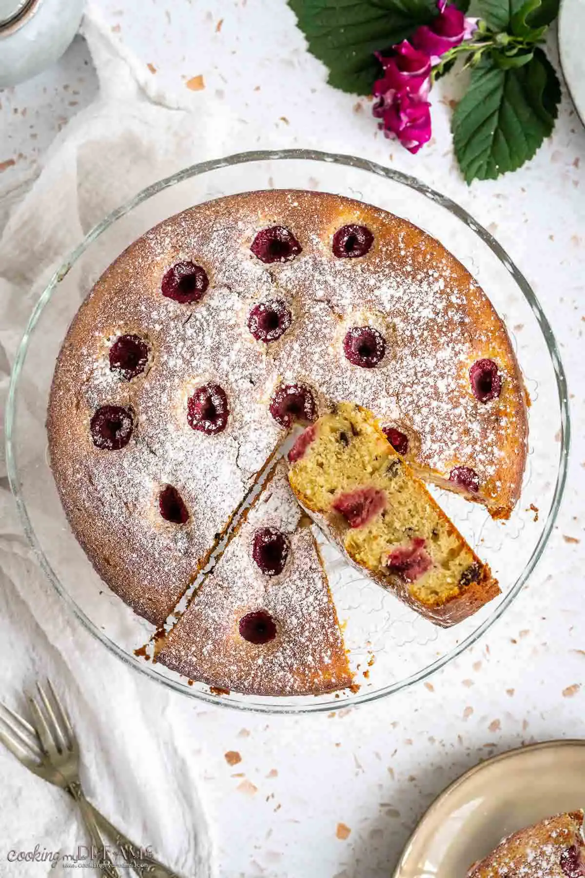 overhead of raspberry ricotta cake with two cut slices